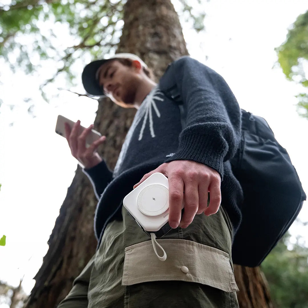 Man using travel charger in the forest