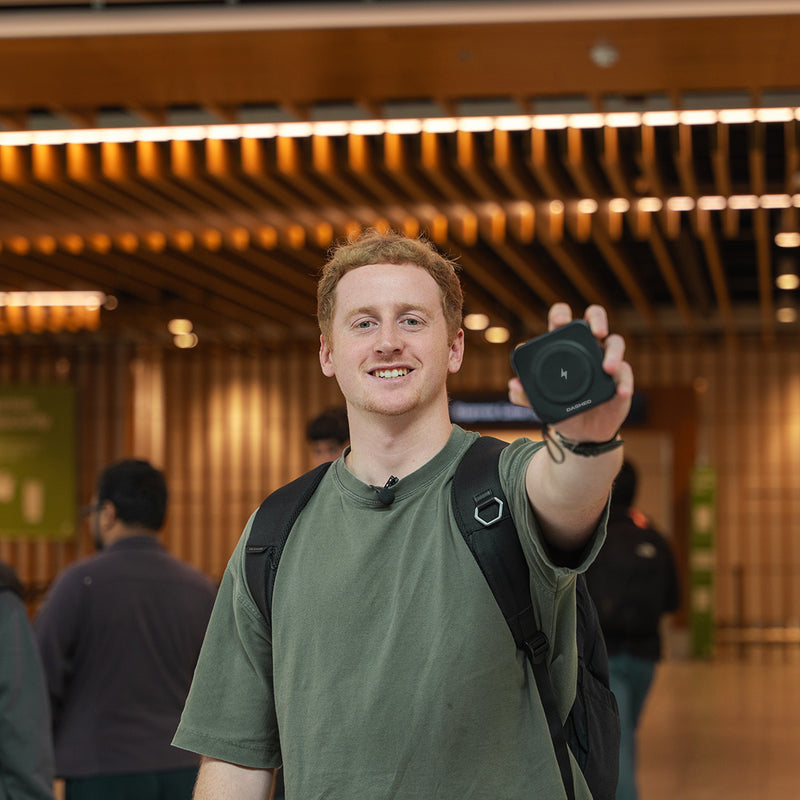 Man Holding Black Travel Charger in Airport